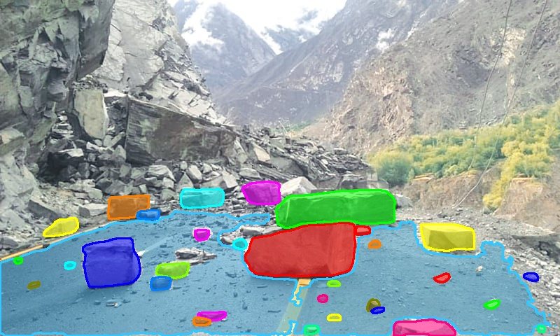 Dashcam frame of a road with fallen rocks masked as obstructions